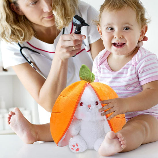 Bébé chez le médecin joue avec la peluche lapin carotte
