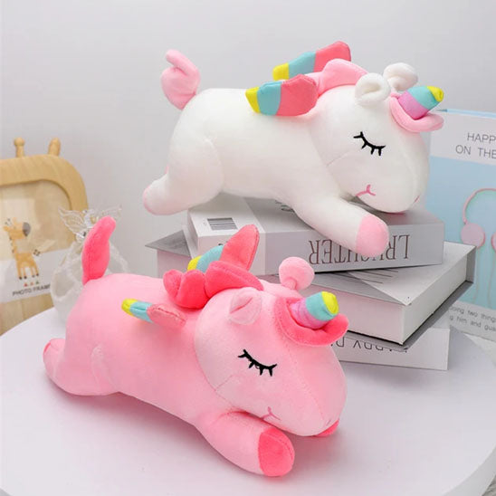 licornes-peluches-rose-multicouleurs-sur-trois-livres-sur-table