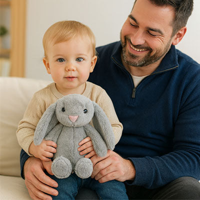 Papa avec son fils qui tient la peluche lapin gris