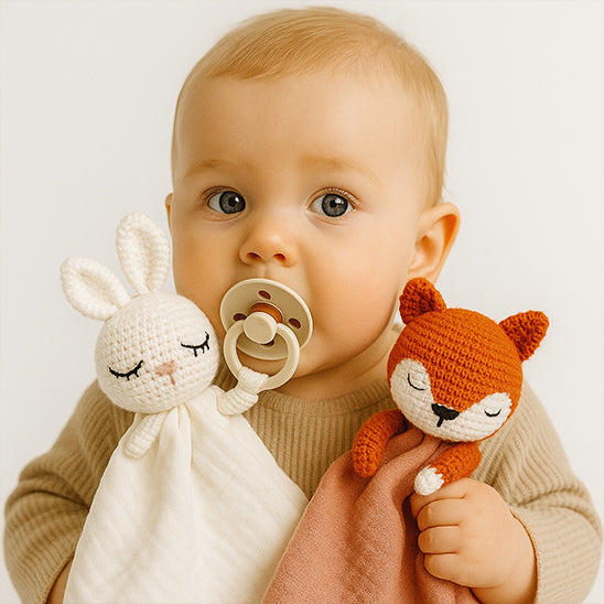 bébé avec une suce tient une doudou bebe renard et lapin 