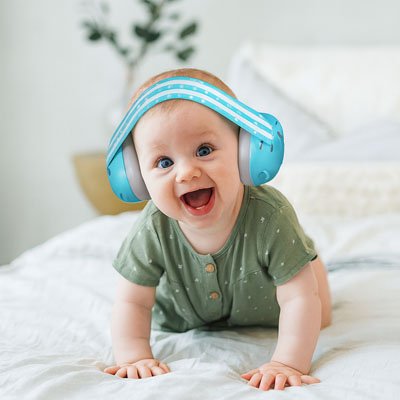 Enfant éveillé portant un casque anti bruit bleu pour protéger ses oreilles des sons forts