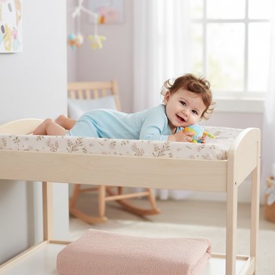 Housse matelas à langer bébé souriant sur la chaise à langer