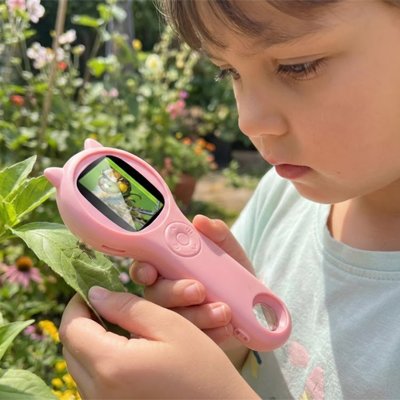 fille regarde avec son Microscope de poche rose une feuille verte