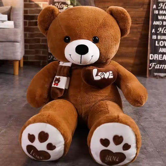 ours-en-peluche-brun-assis-par-terre-avec-écharpe
