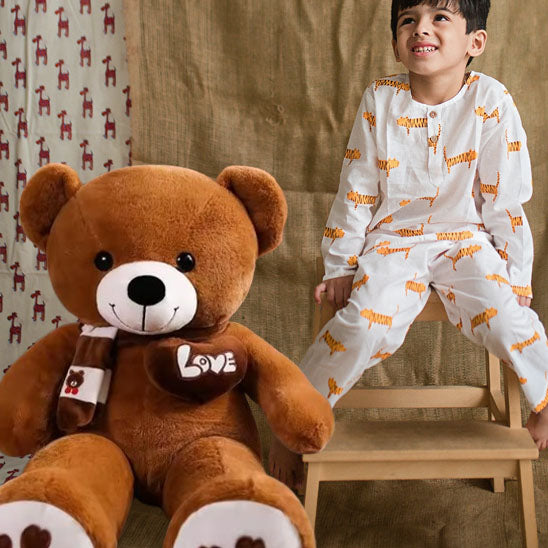 ours-en-peluche-brun-fonce-love-avec-enfant-avec-pyjama-assis-table