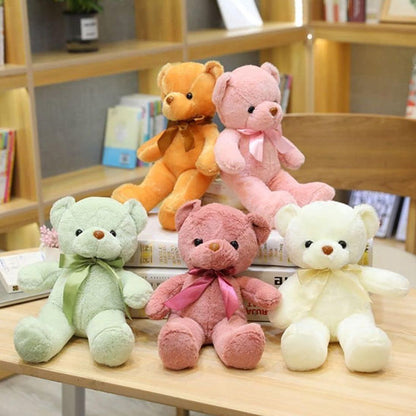 peluches en ours multicouleurs sur des livres table en bois