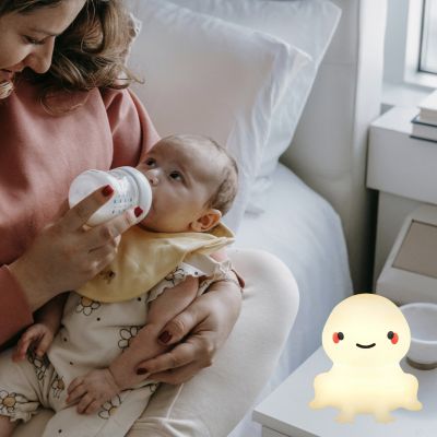 Maman qui allaite bébé avec une veilleuse bébé grenouille USB rechargeable sur la table de chevet
