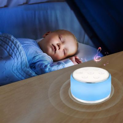 Chambre de bébé apaisée avec veilleuse bruit blanc et lumière allumé à côté du berceau.