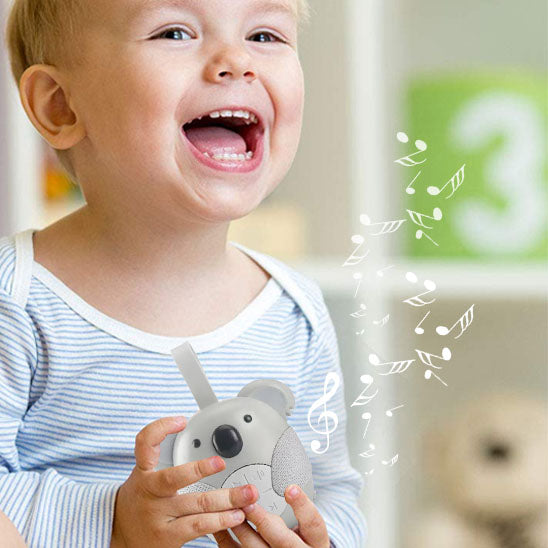 veilleuse bruit blanc et lumière avec mélodie dans les mains de l'enfant souriant