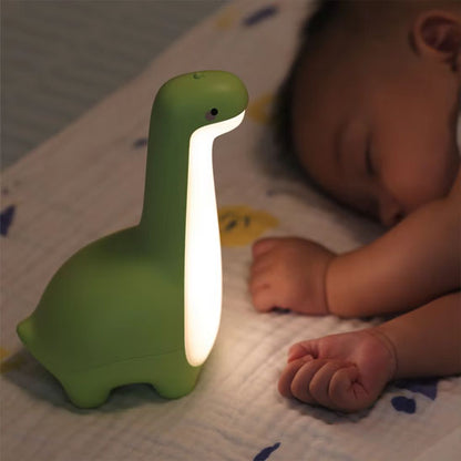 veilleuse-dinosaure-verte-allumee-bébé-dort-sur-côté