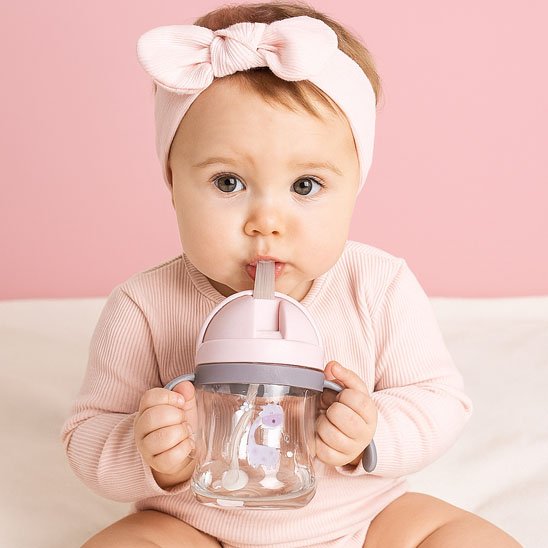 Verre bebe fille boit tient deux poignées